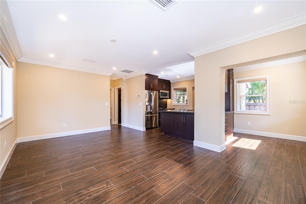 An empty room with beige walls, dark wood-look tile flooring, and a single window — 623 FLORIDA STREET, ORLANDO, FL