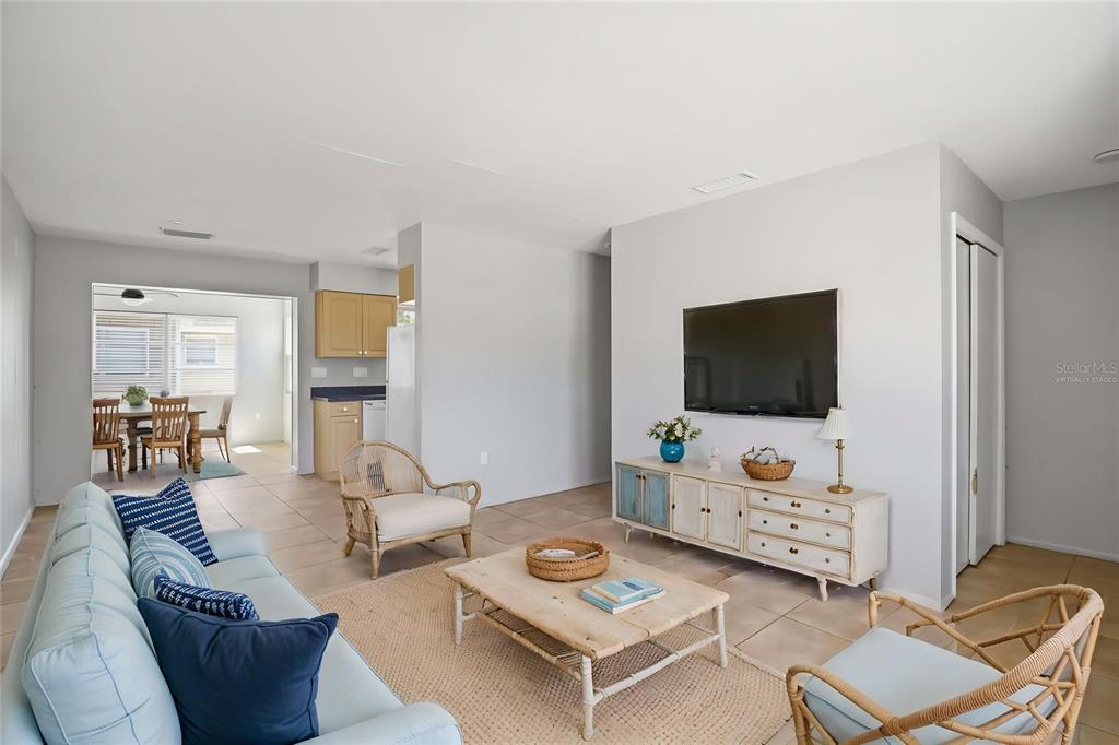 A living room features light blue furniture, a wooden coffee table, and a wall-mounted television — 304 LANTANA AVENUE, SARASOTA, FL