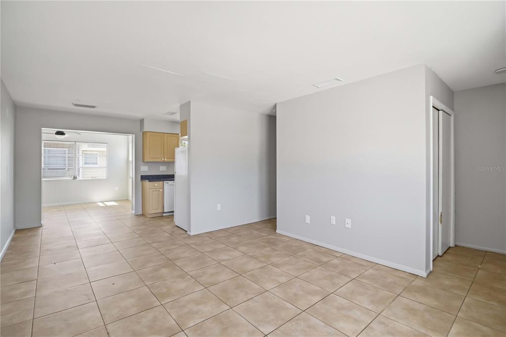 An open-concept room features light-colored tile flooring, gray walls, and a small kitchen area — 304 LANTANA AVENUE, SARASOTA, FL