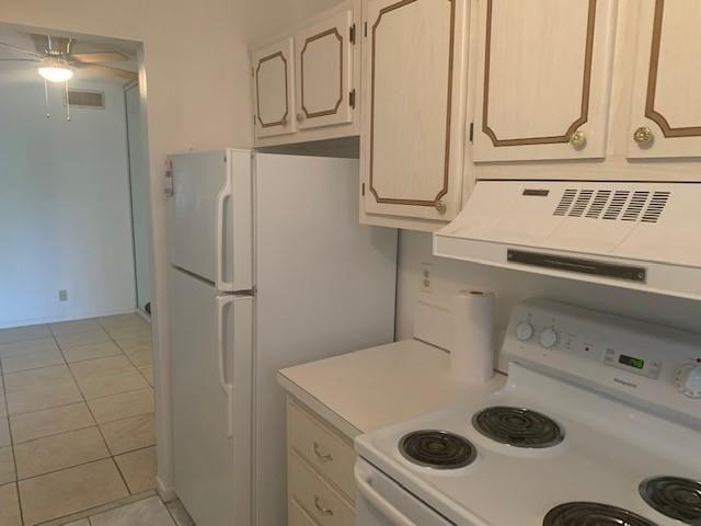 A kitchen features white cabinets, a white refrigerator, and a white electric stove — 270 Layne Boulevard # 308, Hallandale Beach FL 33009, HALLANDALE BEACH, FL
