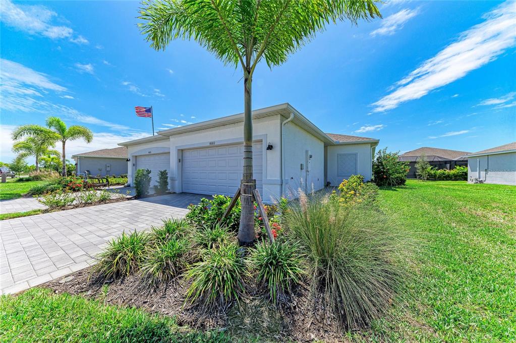 A single-story house with a two-car garage, a palm tree, and a paved driveway — 8682 SEASALT LOOP, ENGLEWOOD, FL