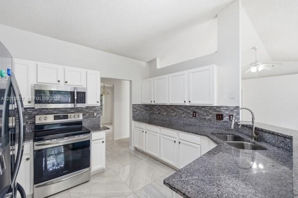 A kitchen features white cabinets, granite countertops, stainless steel appliances, and a tiled backsplash — 7608 Deland Ave, Fort Pierce FL 34951, FORT PIERCE, FL
