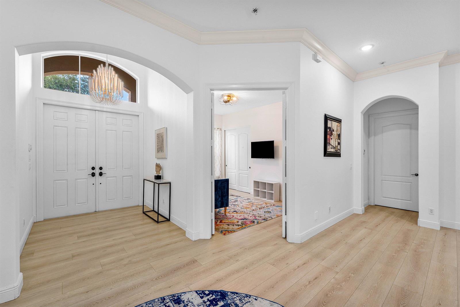A bright foyer features light wood flooring, an arched entryway, and double front doors — 2068 Wightman Drive, Wellington FL 33414, WELLINGTON, FL