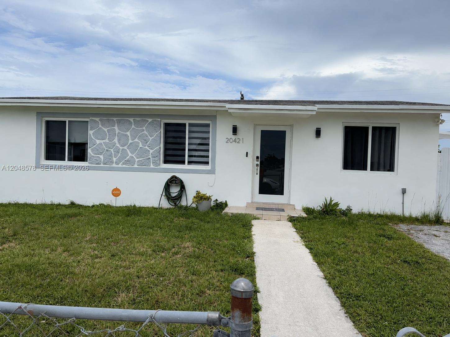 A single-story white house features a stone accent wall, a front door, and a walkway — 20421 SW 118th Ave, Miami FL 33177, MIAMI, FL