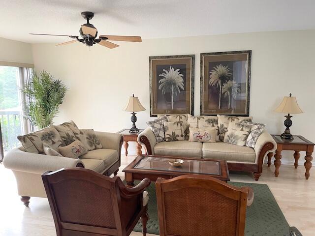 A living room features two beige sofas, two wooden armchairs, and a central coffee table — 2306 FAIRWAY Drive S, Jupiter FL 33477, JUPITER, FL