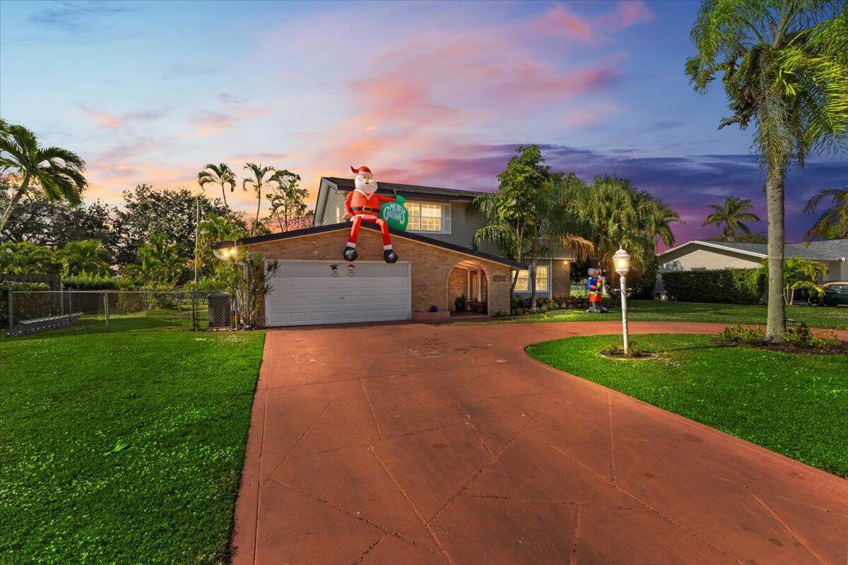 A two-story house with a brick facade, a red driveway, and a large inflatable Santa — 3179 Hoylake Road, Lake Worth FL 33467, LAKE WORTH, FL