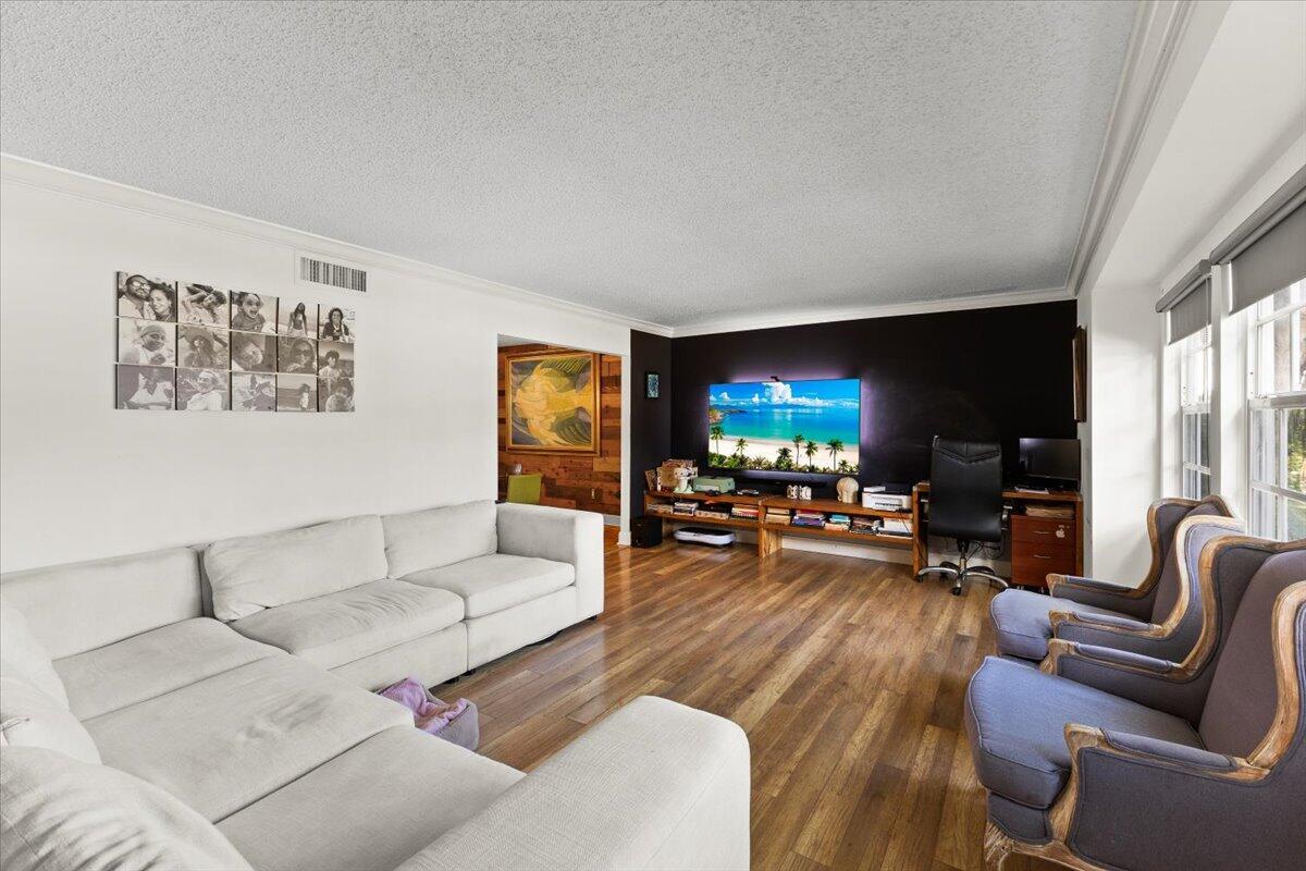 A living room features a white sectional sofa, wood floors, and a dark accent wall — 3179 Hoylake Road, Lake Worth FL 33467, LAKE WORTH, FL