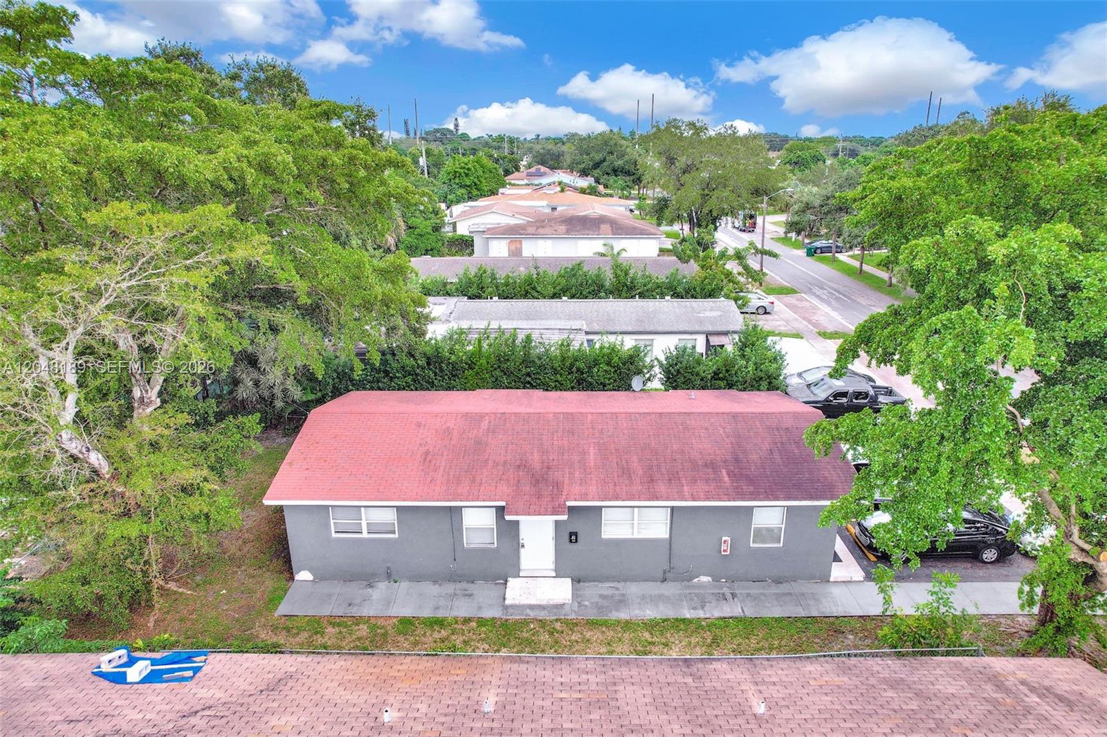 An aerial view shows a gray single-story house with a red roof and a driveway — 746 SW 4th St # 1, Dania Beach FL 33004, DANIA BEACH, FL