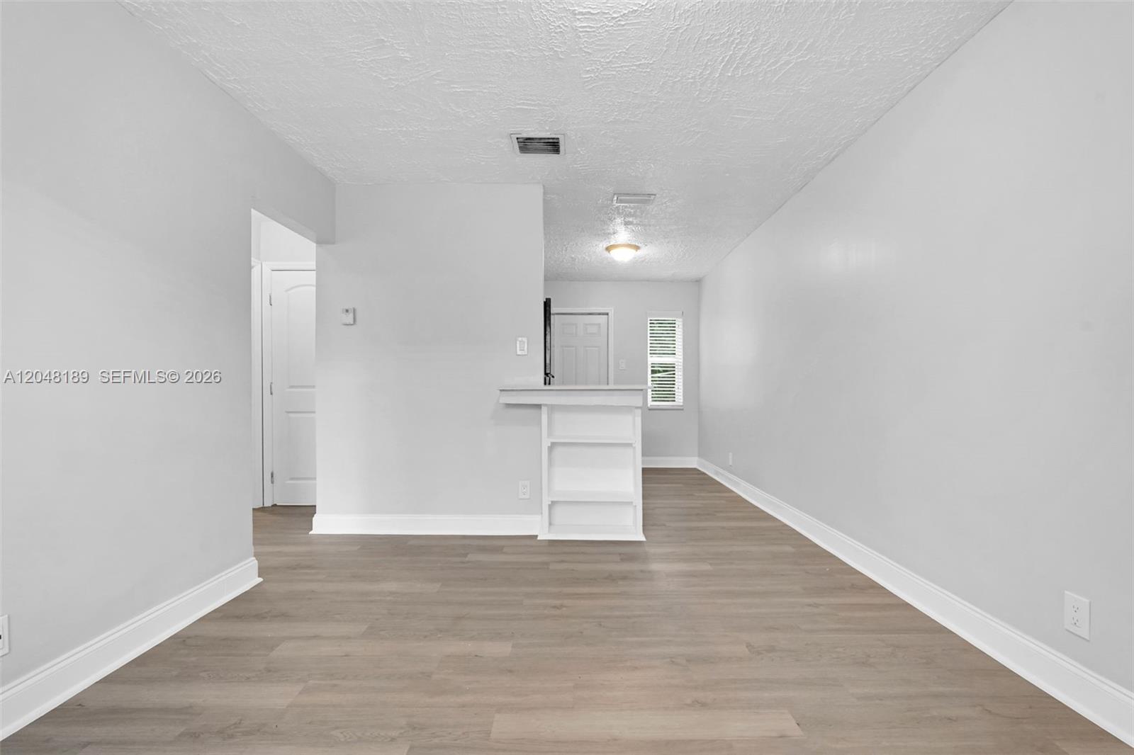 A room with light gray walls, wood-look flooring, and a small white breakfast bar — 746 SW 4th St # 1, Dania Beach FL 33004, DANIA BEACH, FL
