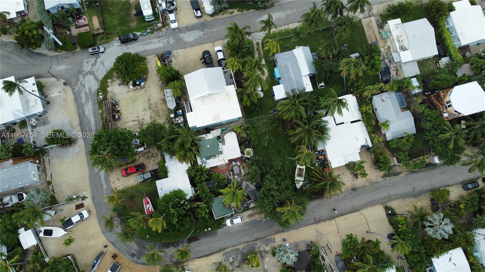 An aerial view shows several houses with white roofs surrounded by palm trees and vehicles — 77 S Conch Ave, Marathon FL 33050, MARATHON, FL