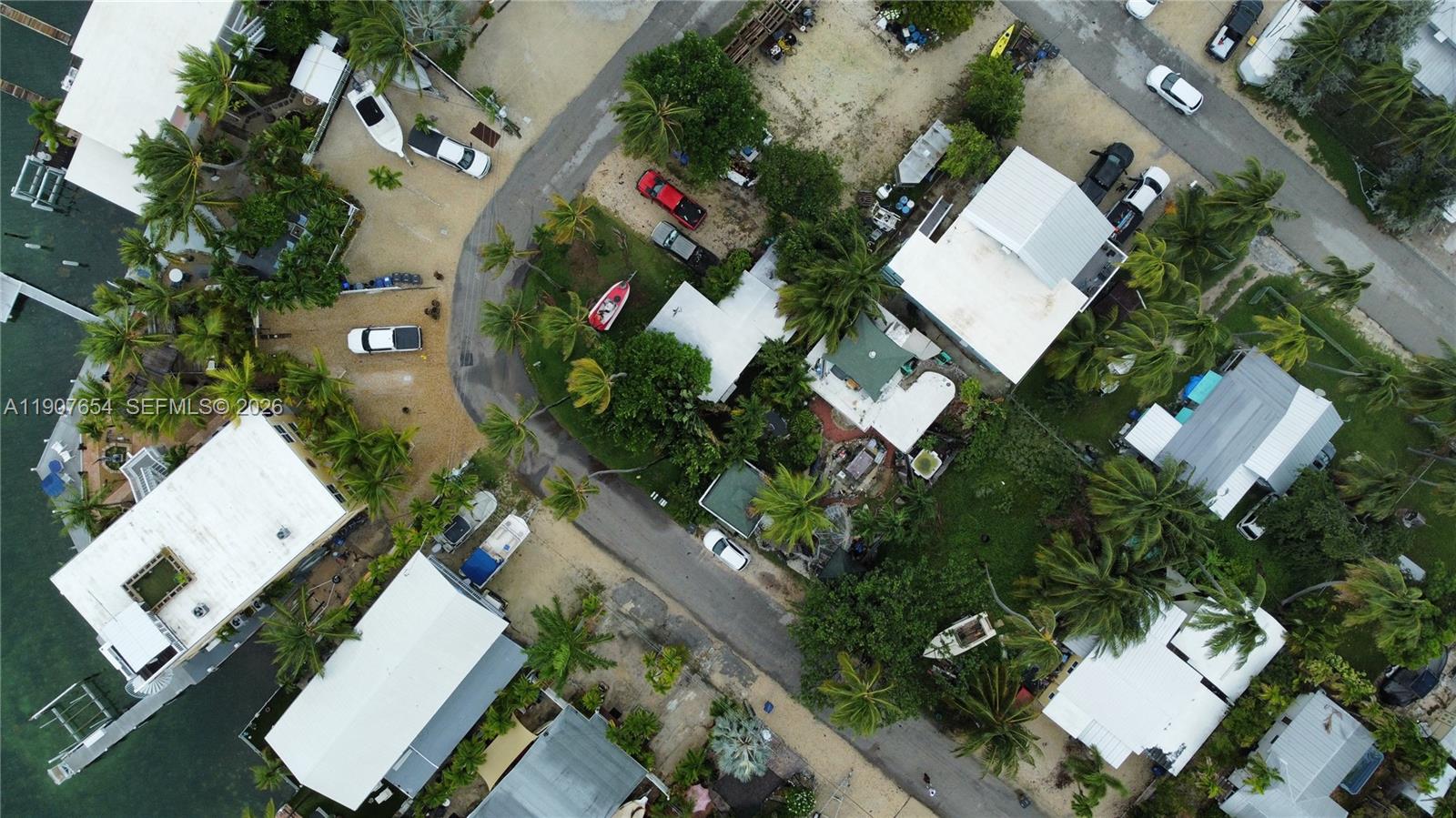 An aerial view shows several houses with white roofs, palm trees, and parked vehicles — 77 S Conch Ave, Marathon FL 33050, MARATHON, FL