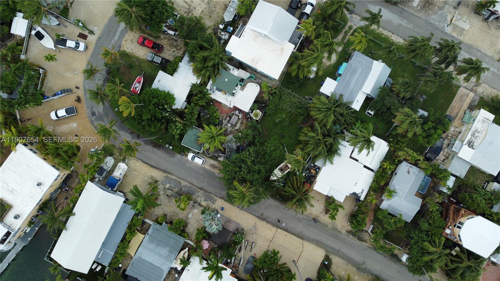 An aerial view shows several houses with white roofs surrounded by palm trees and vehicles — 77 S Conch Ave, Marathon FL 33050, MARATHON, FL