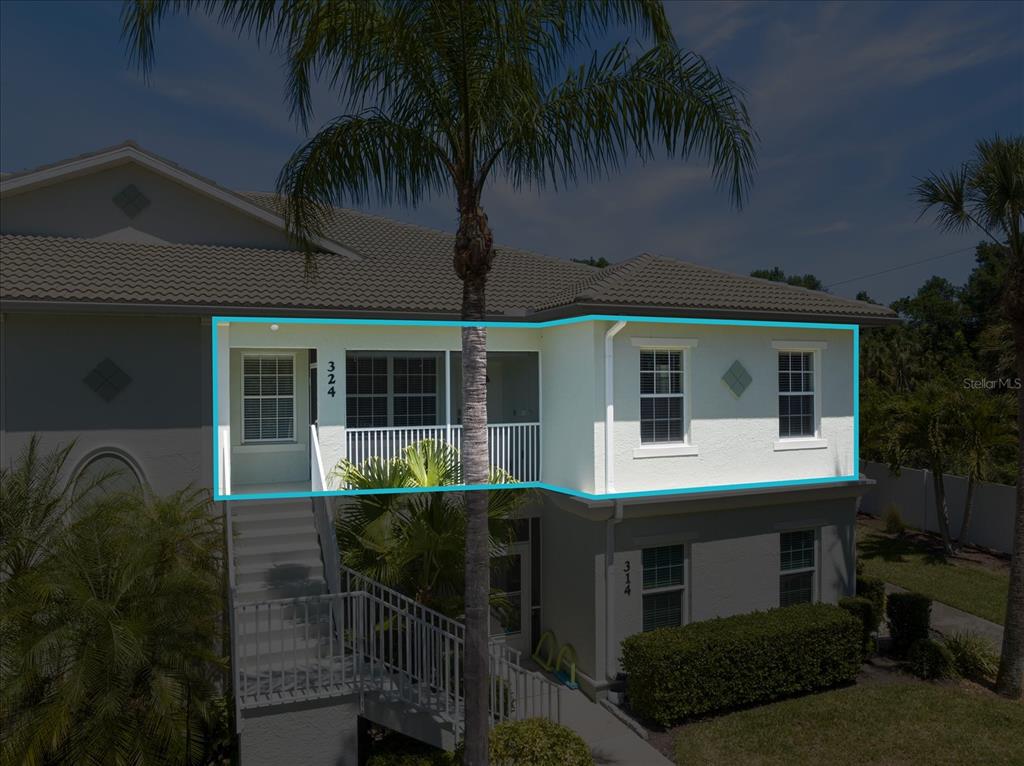 An exterior view of a two-story building featuring an upper-level balcony with unit number 324 — 300 GARDENS EDGE DRIVE UNIT 324, VENICE, FL