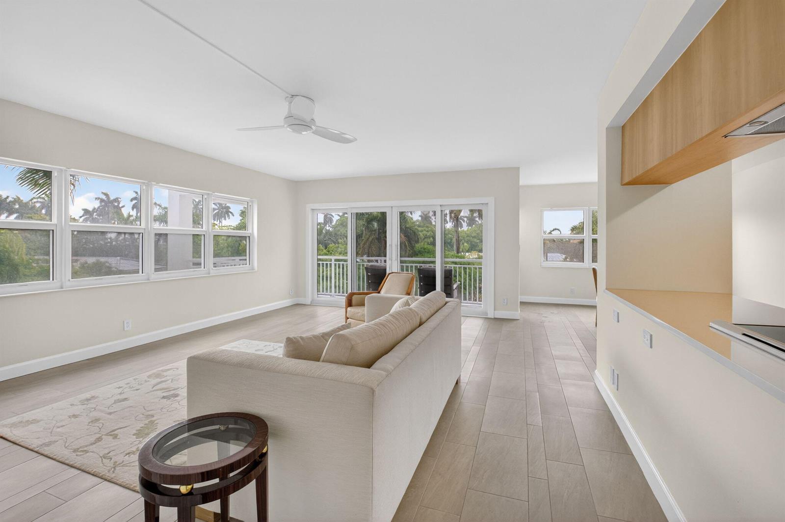 A living room features light tile floors, a beige sofa, and sliding doors to a balcony — 1000 Lowry Street # 3e, Delray Beach FL 33483, DELRAY BEACH, FL