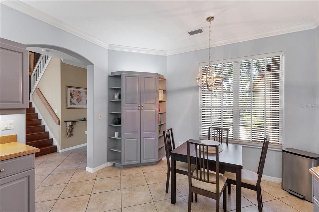 A dining area features a table, chairs, a gray storage unit, and tile flooring — 7263 REGINA ROYALE UNIT 3, SARASOTA, FL
