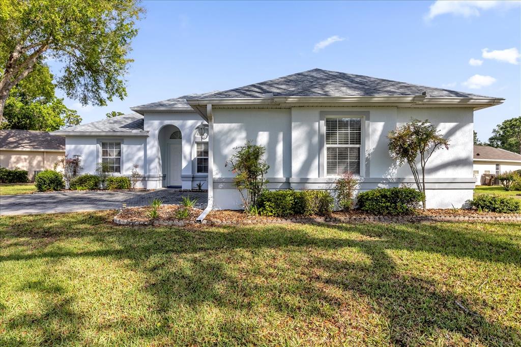 A single-story white house with a gray shingled roof and a paved driveway — 6359 SW 117TH LOOP, OCALA, FL