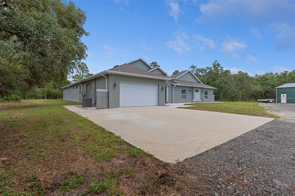 A gray single-story house with a two-car garage and a concrete driveway — 14610 HIDDEN DEER TRAIL, BROOKSVILLE, FL