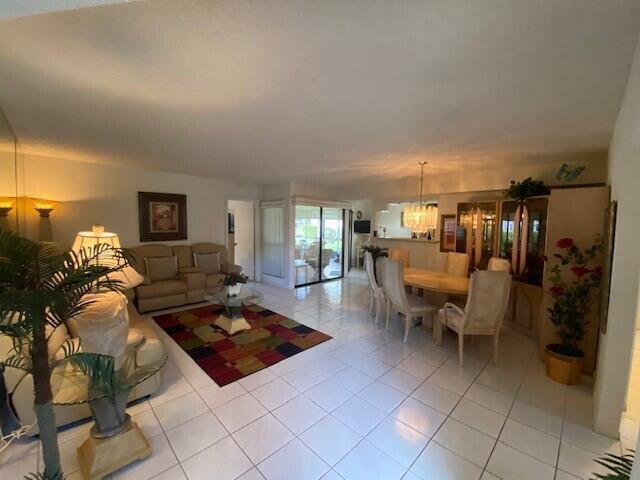 A living room and dining area with tile floors, a colorful rug, and beige furniture — 3367 Perimeter Drive, FL 33467, FL