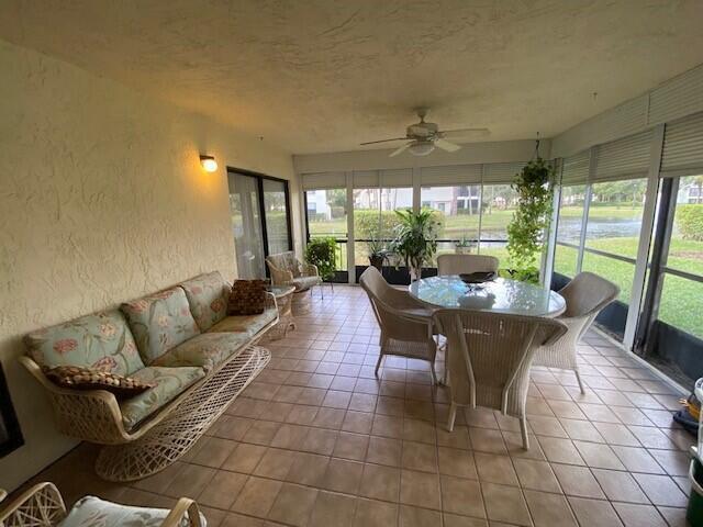 A screened-in patio features tile flooring, a wicker sofa, and a dining set — 3367 Perimeter Drive, FL 33467, FL