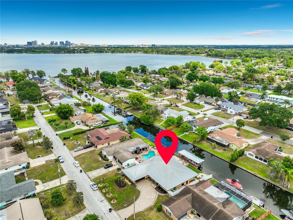 An aerial view shows a waterfront house with a pool and boat dock on a canal — 2404 LAUDERDALE COURT, ORLANDO, FL