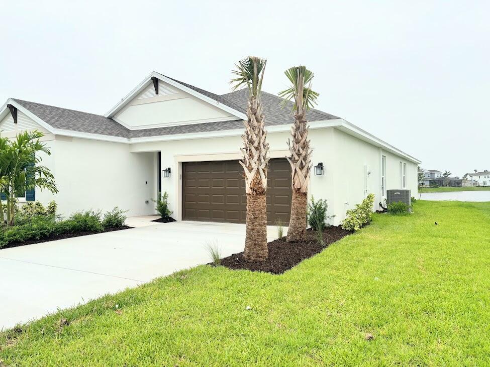 A single-story house with a white exterior, brown garage door, and two palm trees — 9299 SW Lorenzo Way, FL 34987, FL