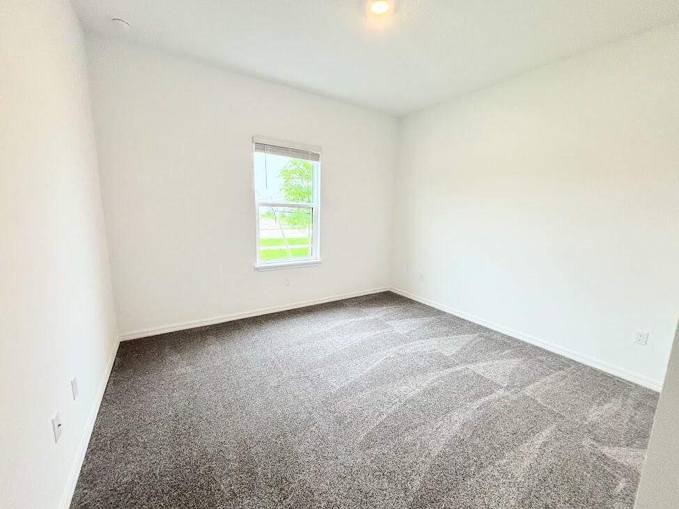 An empty bedroom features white walls, gray carpet, and a single window with blinds — 9299 SW Lorenzo Way, FL 34987, FL