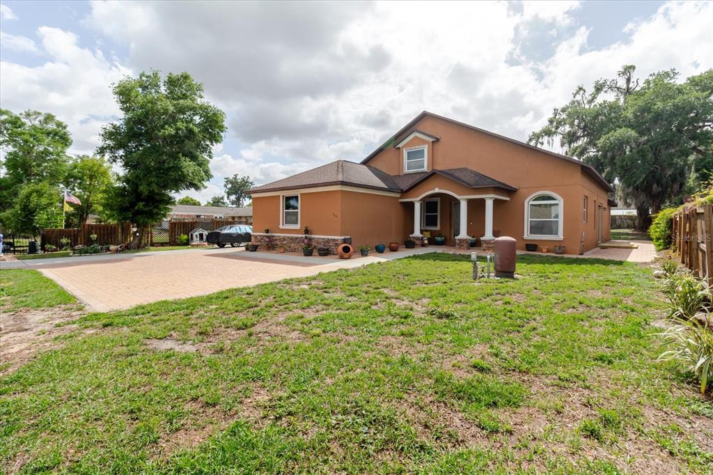 A two-story stucco house with a paved driveway and a front porch with columns — 2603 BISMARK DRIVE, VALRICO, FL