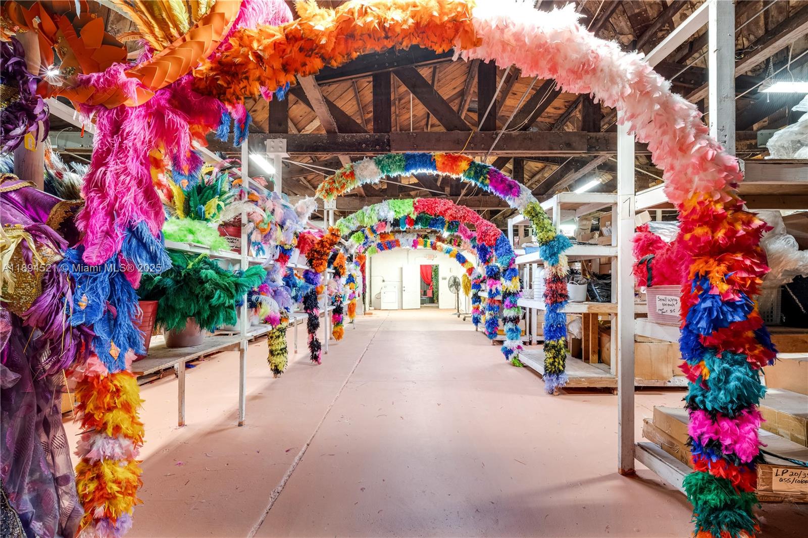 A storage room features rows of shelves decorated with colorful feather arches and costumes — 1121 NW 29th St, Miami FL 33127, MIAMI, FL