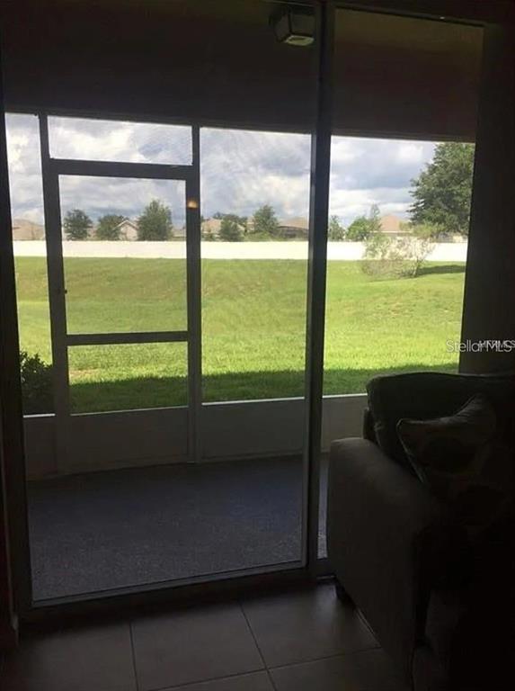 A view from inside a room through a sliding glass door to a screened patio — 1560 CHELSEA DRIVE, DAVENPORT, FL