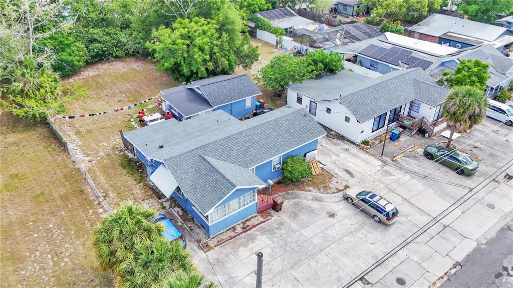 An aerial view shows two blue houses with gray roofs and a large adjacent lot — 26 W POLK AVENUE, LAKE WALES, FL