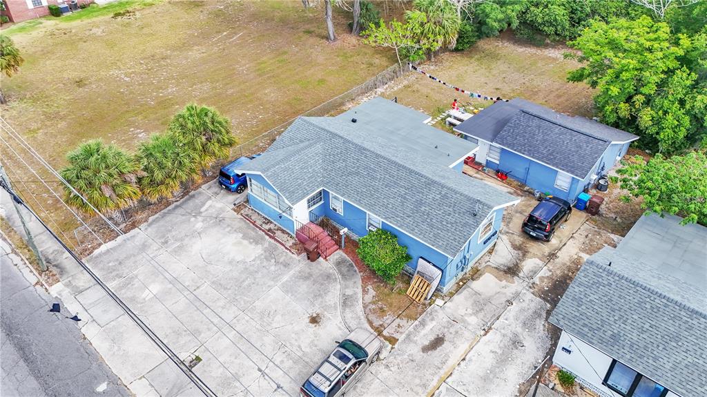 An aerial view shows a blue house with a large concrete driveway and detached garage — 26 W POLK AVENUE, LAKE WALES, FL