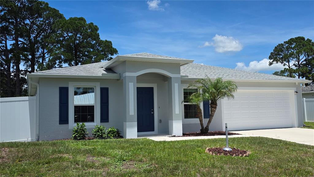 A single-story house with a gray exterior, dark blue door, and a two-car garage — 2135 19TH AVENUE SW, VERO BEACH, FL
