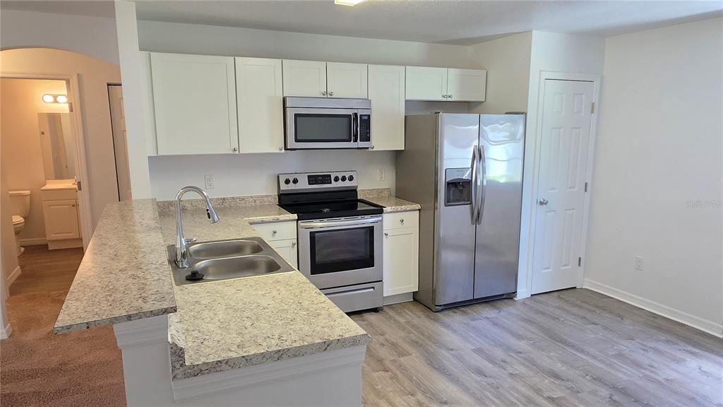 A kitchen with white cabinets, stainless steel appliances, and granite countertops — 2135 19TH AVENUE SW, VERO BEACH, FL