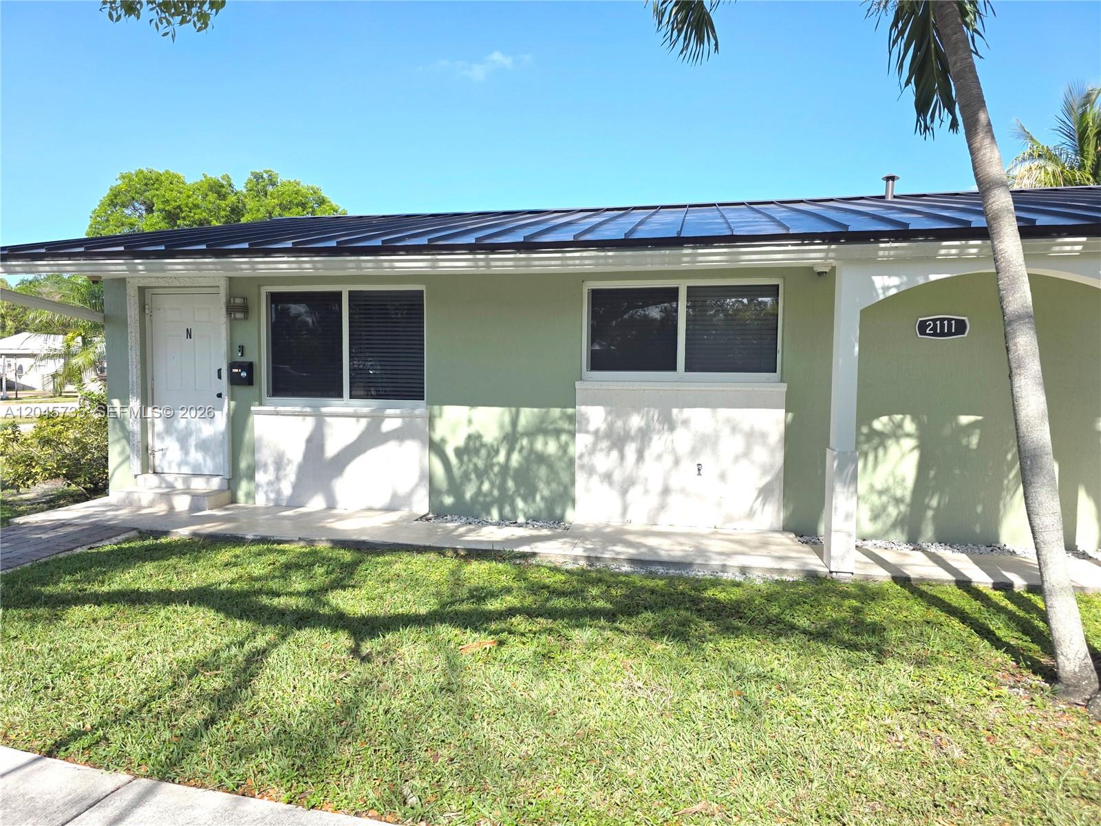A single-story house with a green exterior, a metal roof, and a front lawn — 2111 N 26th Ave, Hollywood FL 33020, HOLLYWOOD, FL