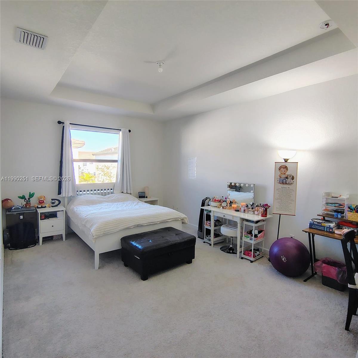A bedroom features a bed, vanity, desk, and carpeted flooring under a tray ceiling — 23074 SW 128th Pl, Goulds FL 33170, GOULDS, FL