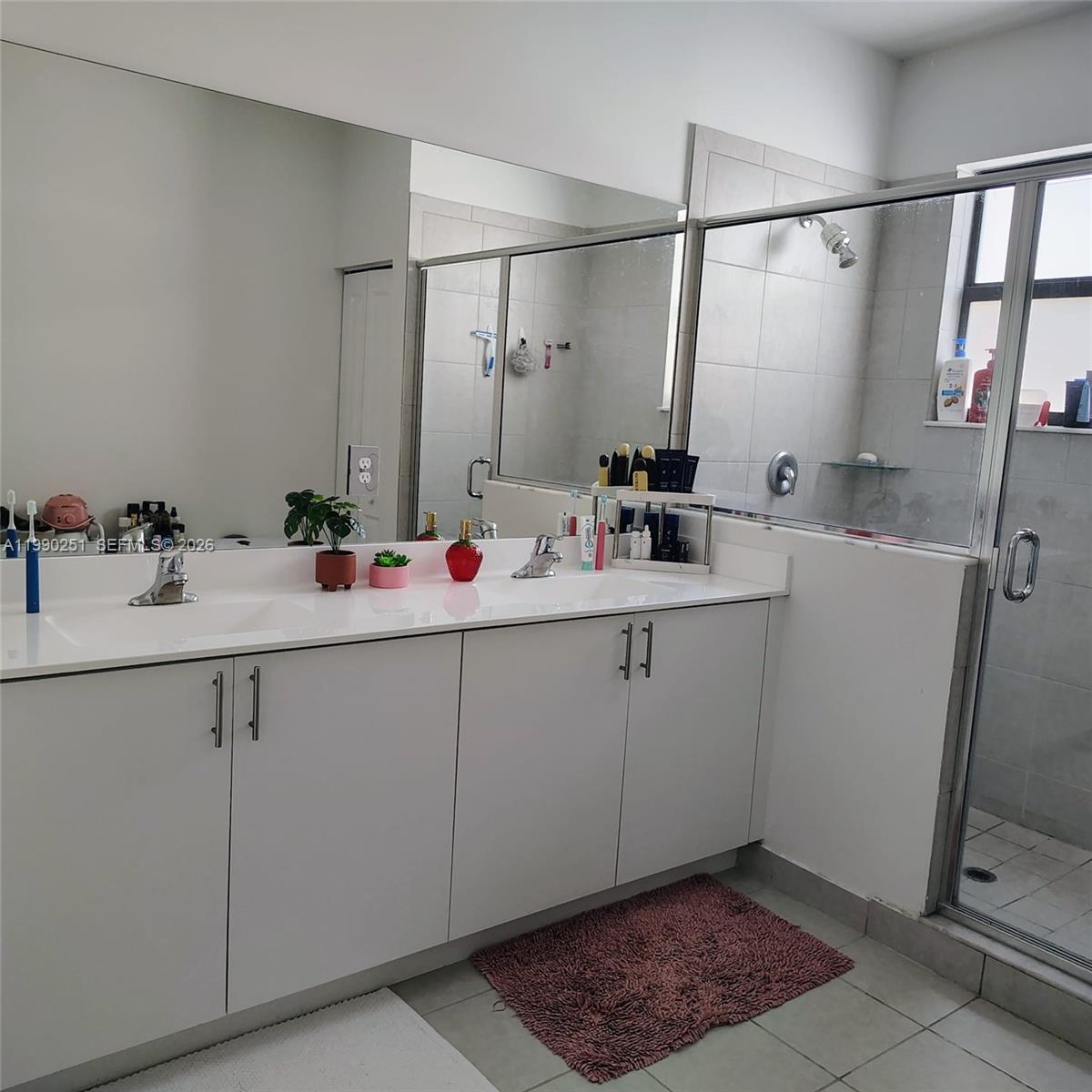 A bathroom features a dual-sink white vanity, a large mirror, and a glass-enclosed shower — 23074 SW 128th Pl, Goulds FL 33170, GOULDS, FL