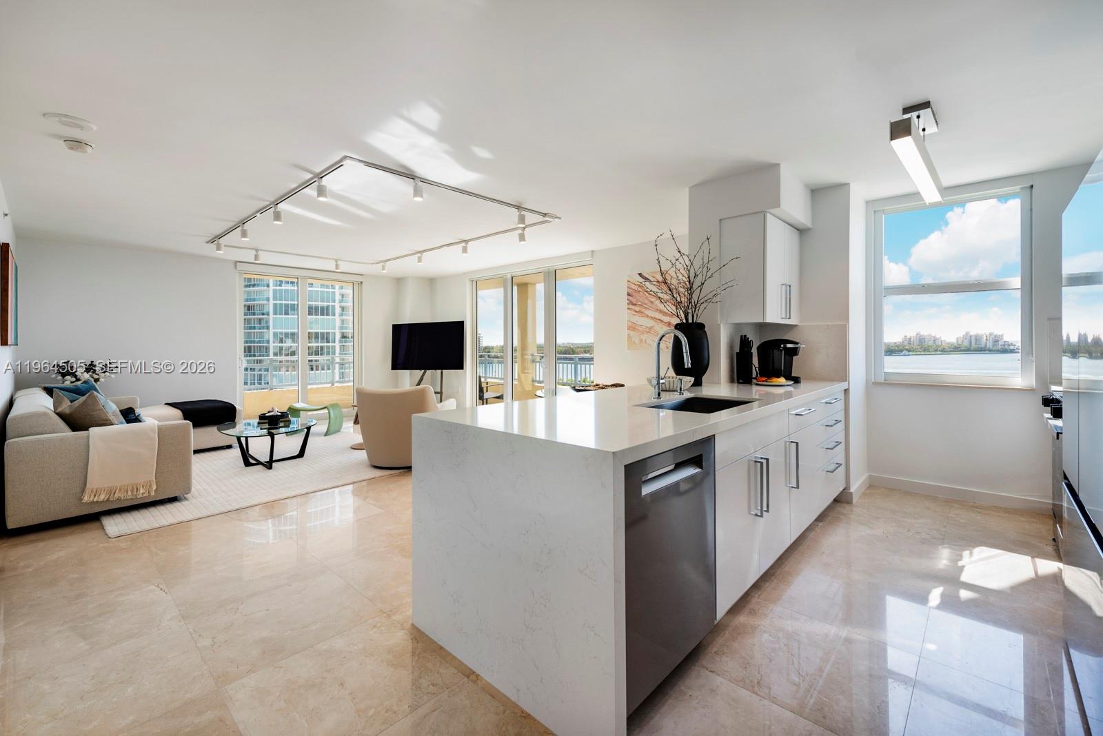 A balcony overlooks a swimming pool and a harbor with a city skyline in distance — 90 Alton Rd # 902, Miami Beach FL 33139, MIAMI BEACH, FL