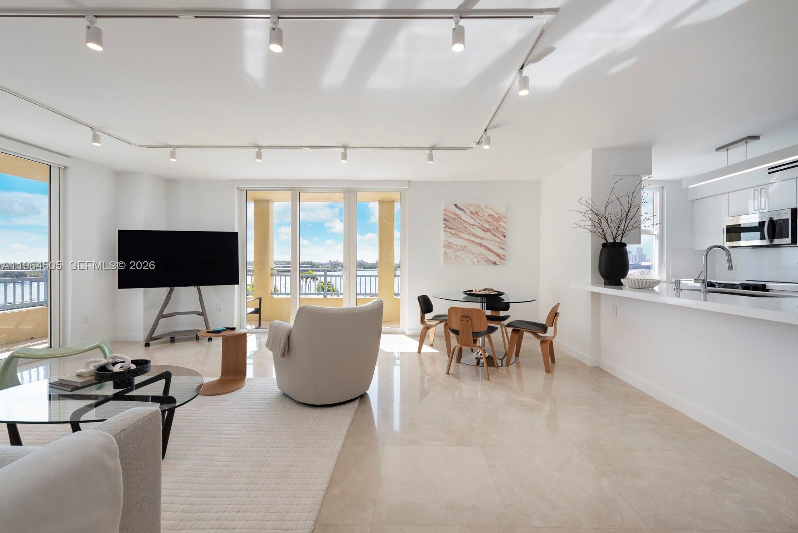 A covered balcony with tile flooring overlooks a swimming pool, marina, and waterway — 90 Alton Rd # 902, Miami Beach FL 33139, MIAMI BEACH, FL