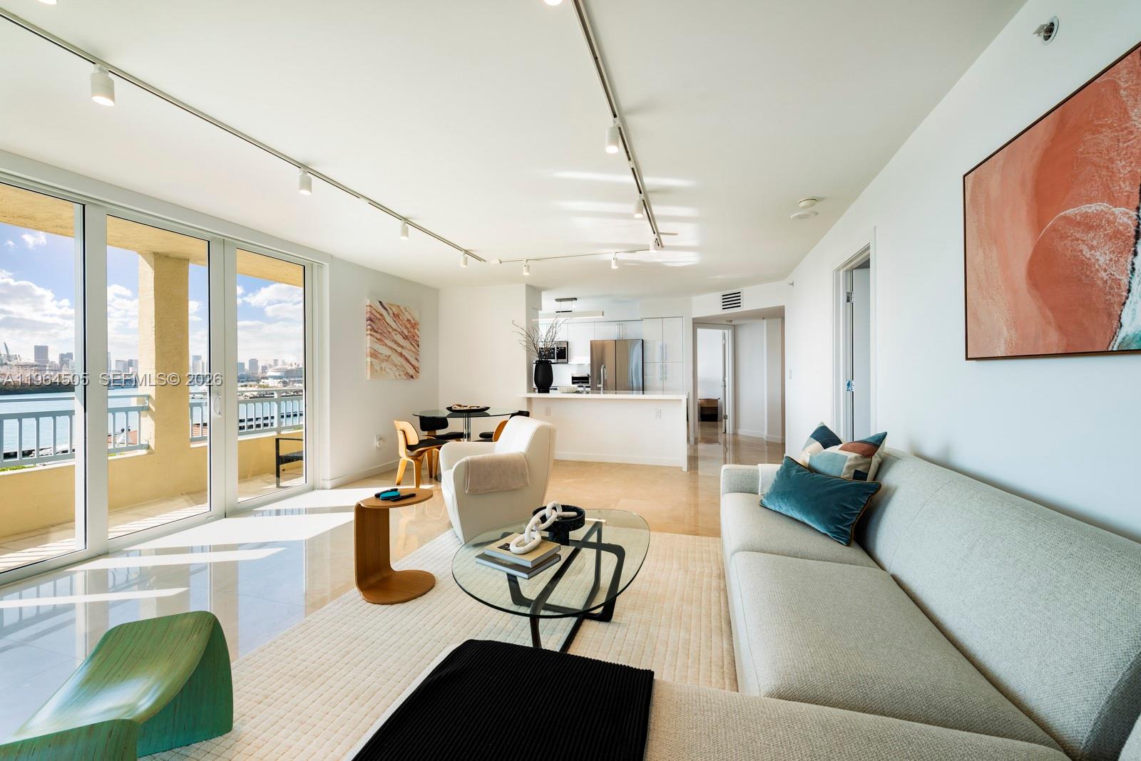 An elevated view of a swimming pool deck overlooking a marina and a city skyline — 90 Alton Rd # 902, Miami Beach FL 33139, MIAMI BEACH, FL