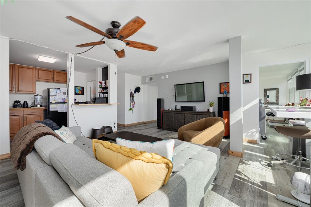 A living room with gray flooring, a gray sectional sofa, and an open kitchen area — 841 4TH AVENUE N UNIT 38, ST PETERSBURG, FL