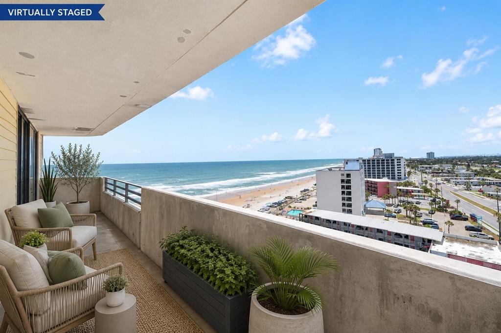 The exterior of a multi-story white apartment building with a glass entrance canopy — 1420 N ATLANTIC AVENUE UNIT 1104, DAYTONA BEACH, FL