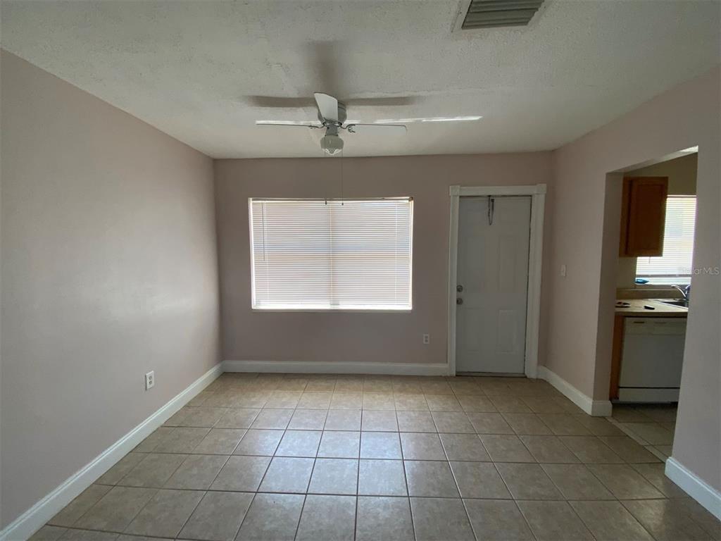 A dining room with light-colored walls, tile flooring, a ceiling fan, and a window — 22017 BEVERLY AVENUE, PORT CHARLOTTE, FL