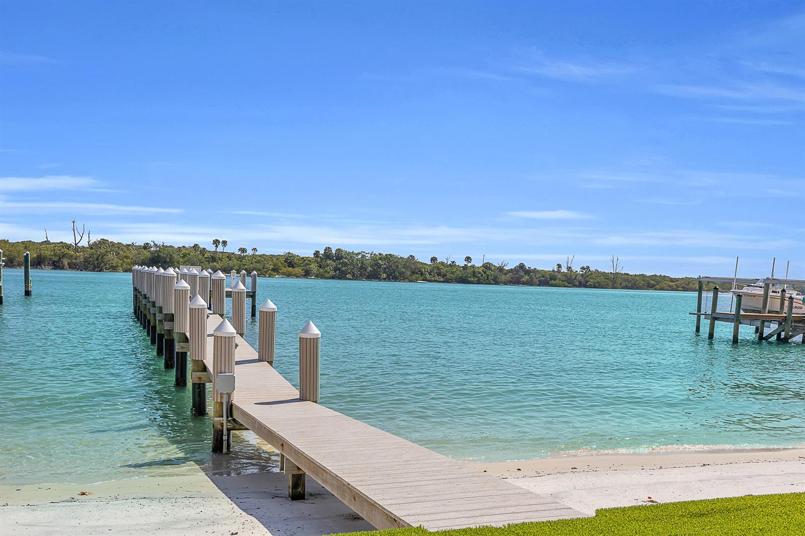 A wooden dock extends into turquoise water from a sandy beach under a blue sky — 18119 SE Federal Highway, Jupiter FL 33469, JUPITER, FL