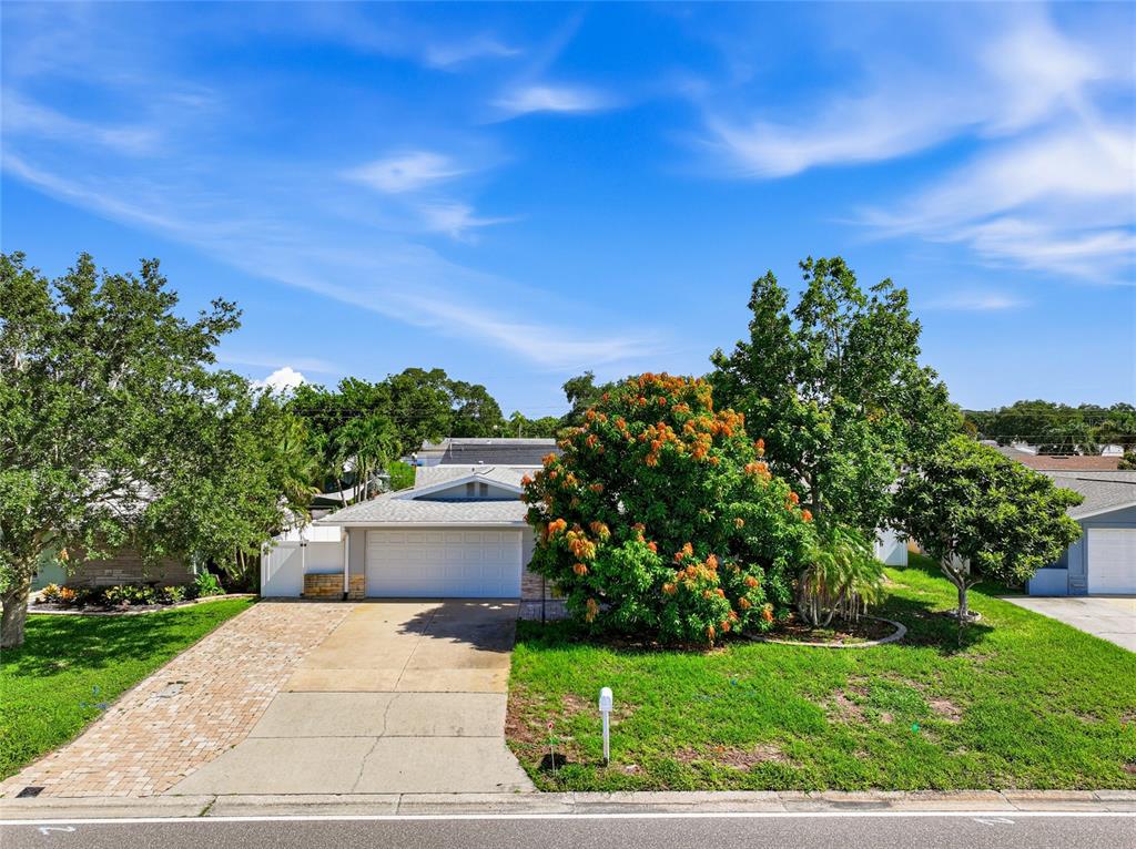 A covered patio features stone walls, brick pavers, and a hanging lantern light fixture — 14233 102ND AVENUE, LARGO, FL