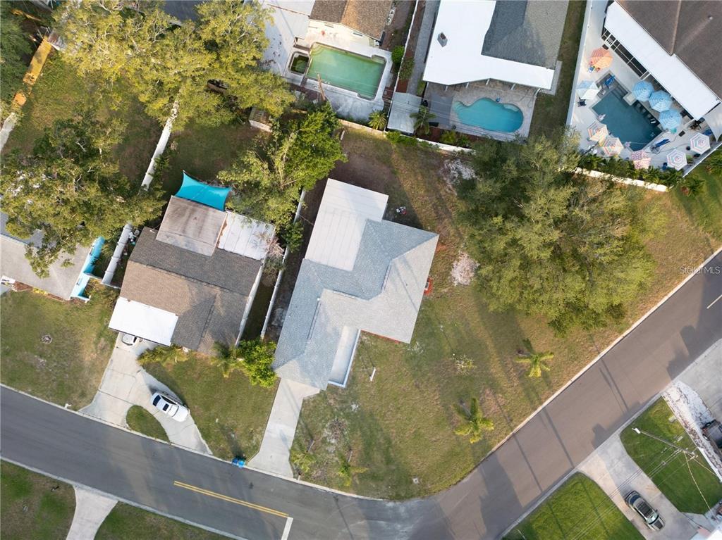 An aerial view shows two adjacent houses with driveways, trees, and swimming pools — 10341 KUMQUAT LANE, SEMINOLE, FL