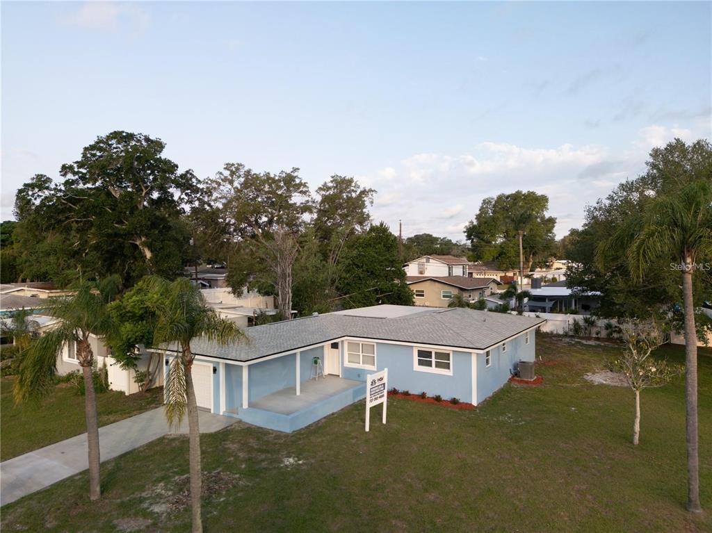 An aerial view of a light blue single-story house with a gray roof and lawn — 10341 KUMQUAT LANE, SEMINOLE, FL
