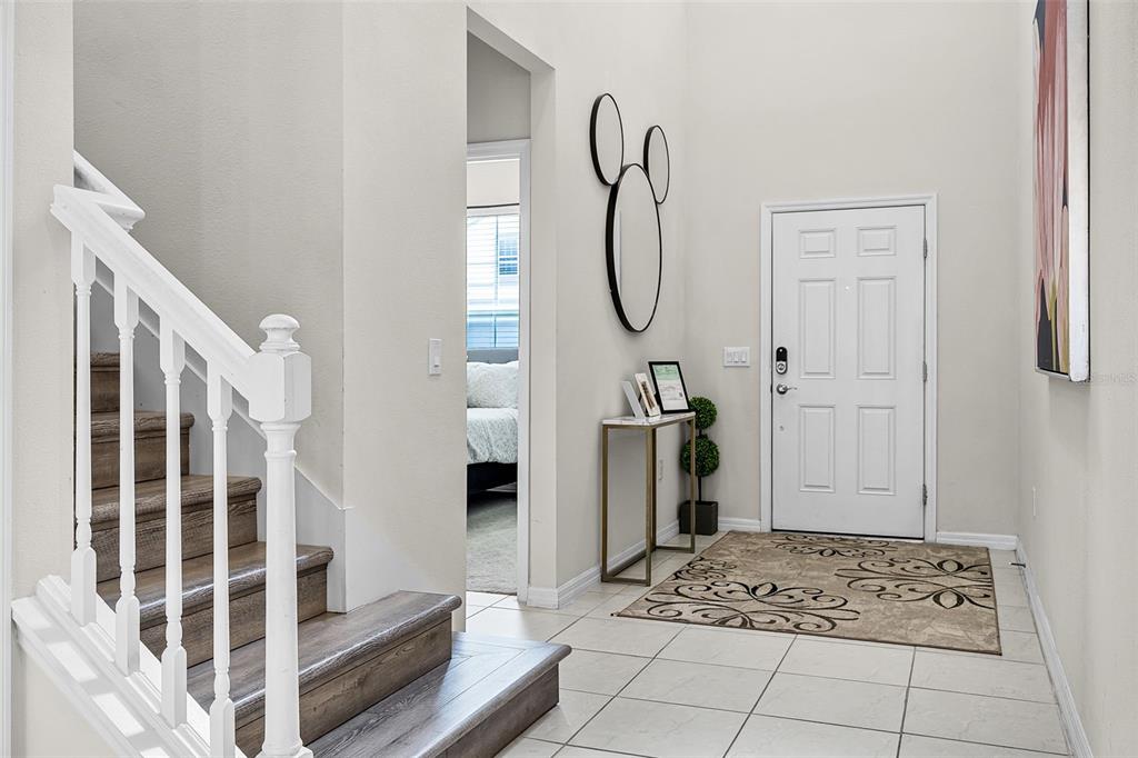 An entryway features a white front door, a staircase with wood treads, and a console table — 3520 LAVENDER DRIVE, DAVENPORT, FL