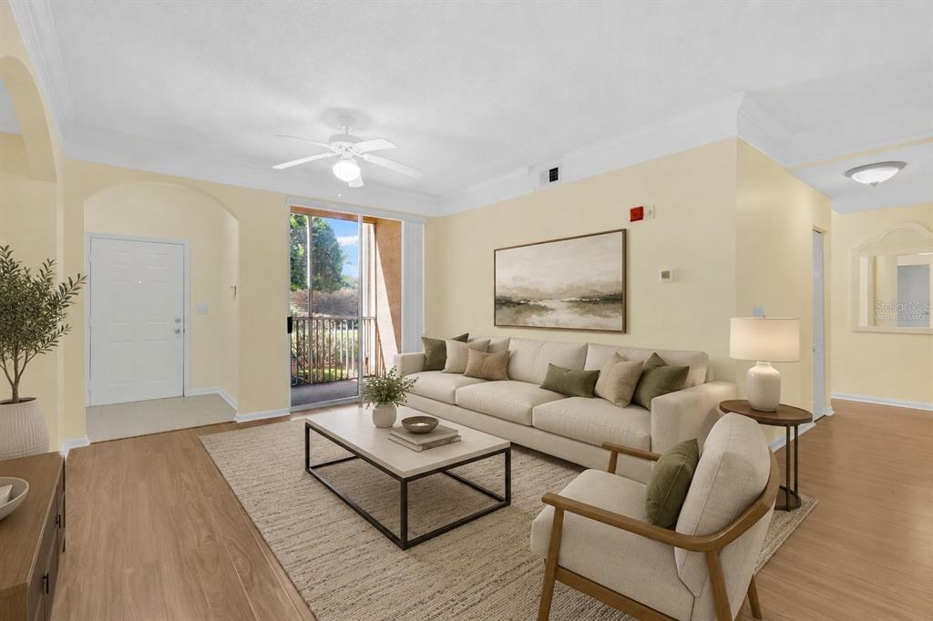 A living room with light-colored walls, wood-look flooring, a sofa, and a sliding glass door — 12111 POPPY FIELD LANE UNIT 109, ORLANDO, FL