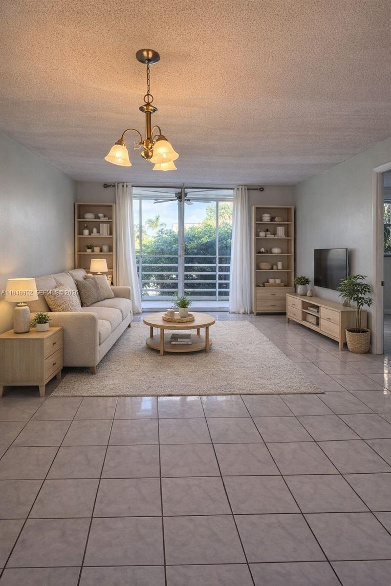 A living room features a beige sofa, a round coffee table, and light wood shelving — 501 E Dania Beach Blvd # 1B, Dania Beach FL 33004, DANIA BEACH, FL