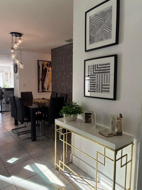 A dining area with a modern chandelier and a white console table with gold legs — 336 GINA LANE, DAVENPORT, FL